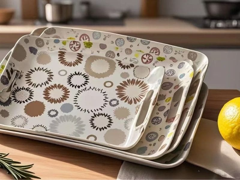 A set of three floral melamine handled trays nested together on a kitchen